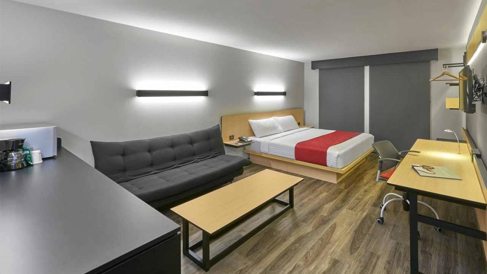 Habitación moderna en León, México con cama cómoda y área de trabajo.