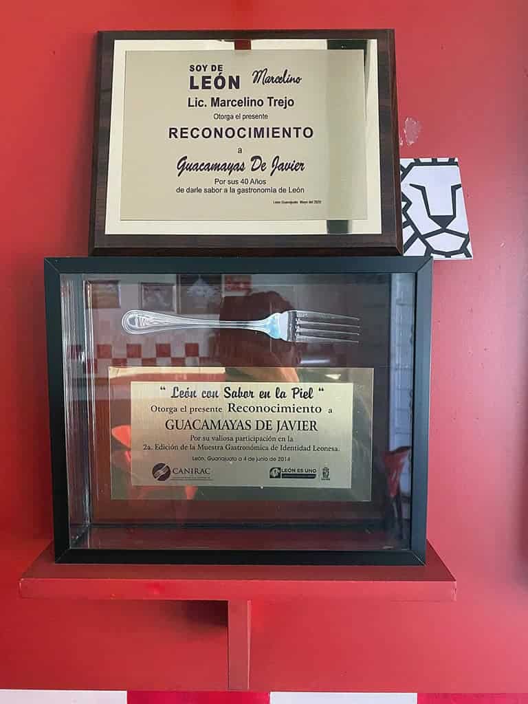 Placa de reconocimiento por 40 a&ntilde;os en gastronom&iacute;a de Le&oacute;n, enmarcada y exhibida en caja de vidrio.