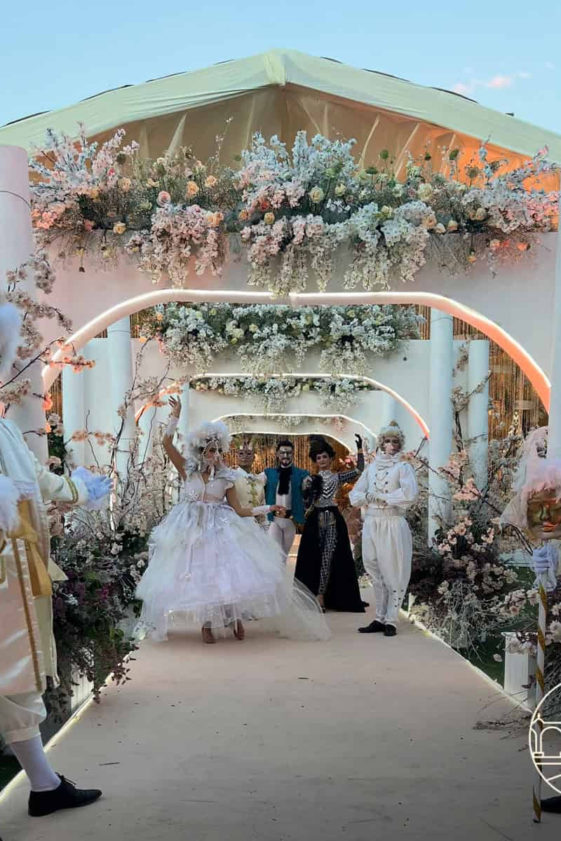 Decoración floral y personajes en disfraces en boda elegante en jardín.