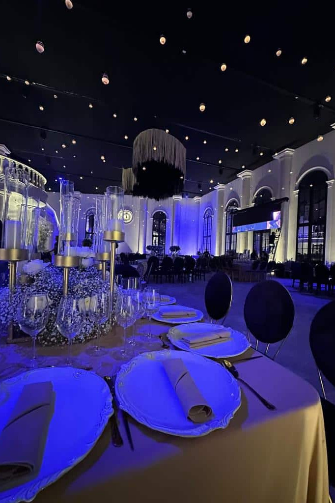 Salón de eventos con decoración moderna, iluminación azul y ambiente sofisticado para celebraciones y eventos especiales.