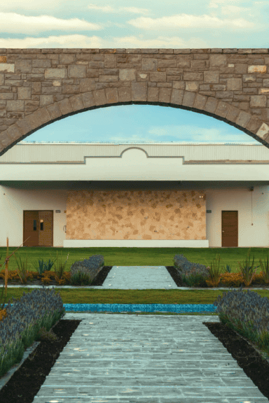 Jardín bien cuidado con sendero y estructura de piedra en León, México, ideal para paseos y eventos culturales en un entorno.