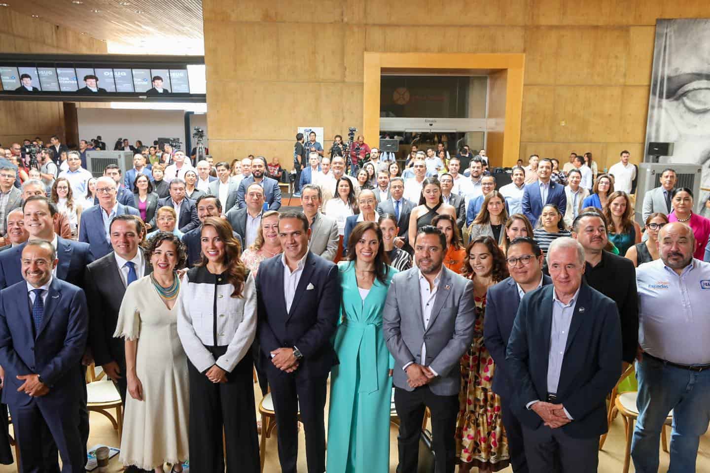 Grupo de profesionales y autoridades en evento oficial en León, mostrando colaboración y liderazgo en un espacio moderno y el.