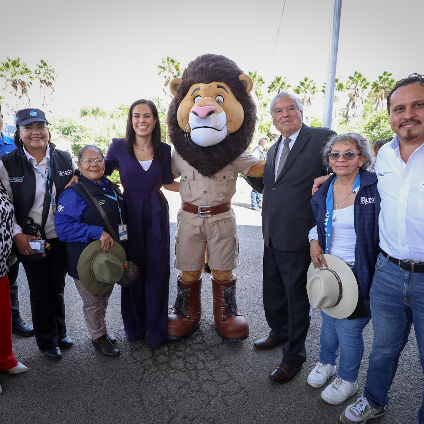 Grupo de turistas y personajes en evento en León, disfrutando de la cultura y la diversión en un ambiente al aire libre.