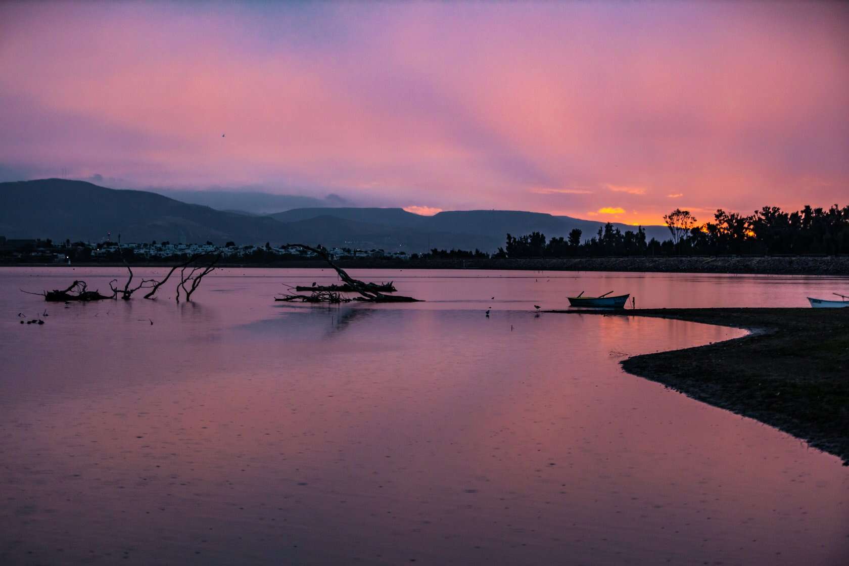 Atardecer en el r&iacute;o de Le&oacute;n, M&eacute;xico, con colores vibrantes y paisaje tranquilo.