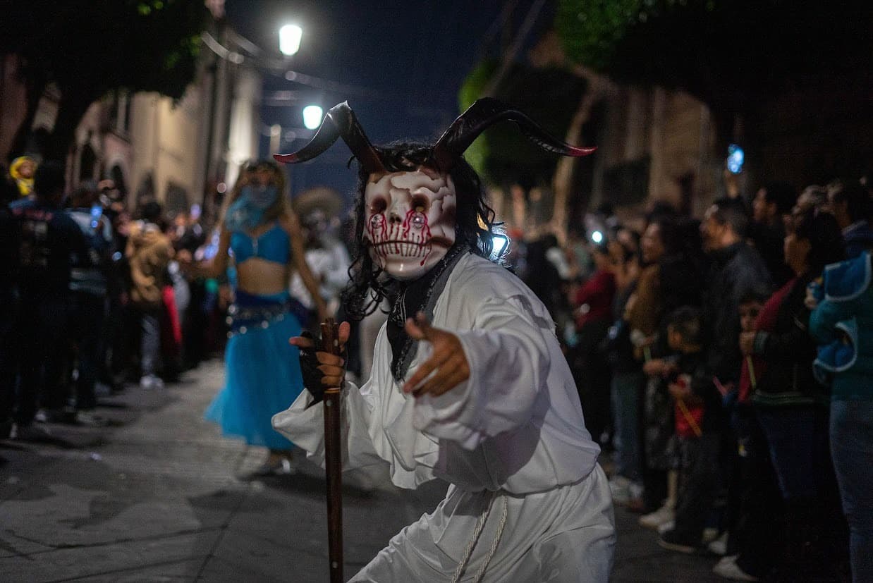 Espectacular disfraz de calavera con cuernos en desfile nocturno en Le&oacute;n, M&eacute;xico, con multitud de espectadores disfrutando la.