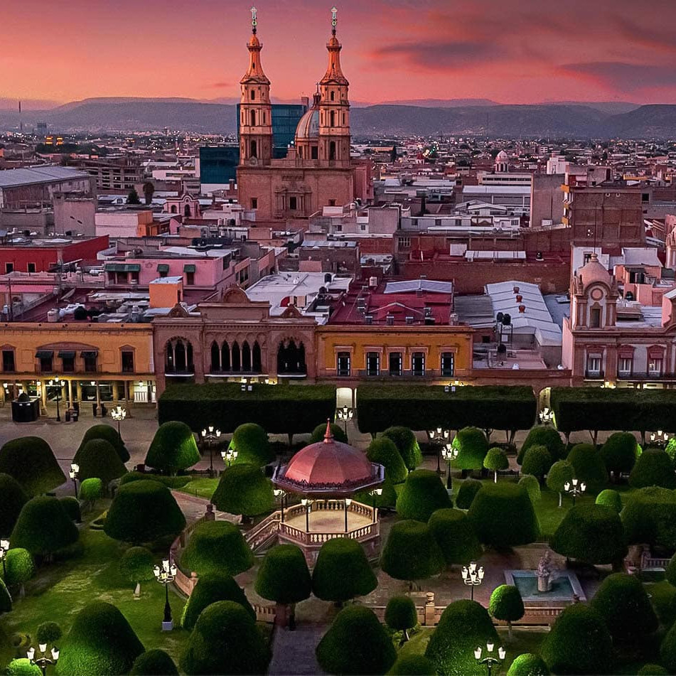 Catedral de León y hermoso jardín central con fuentes y áreas verdes, ideal para pasear y disfrutar del atardecer en la ciuda.