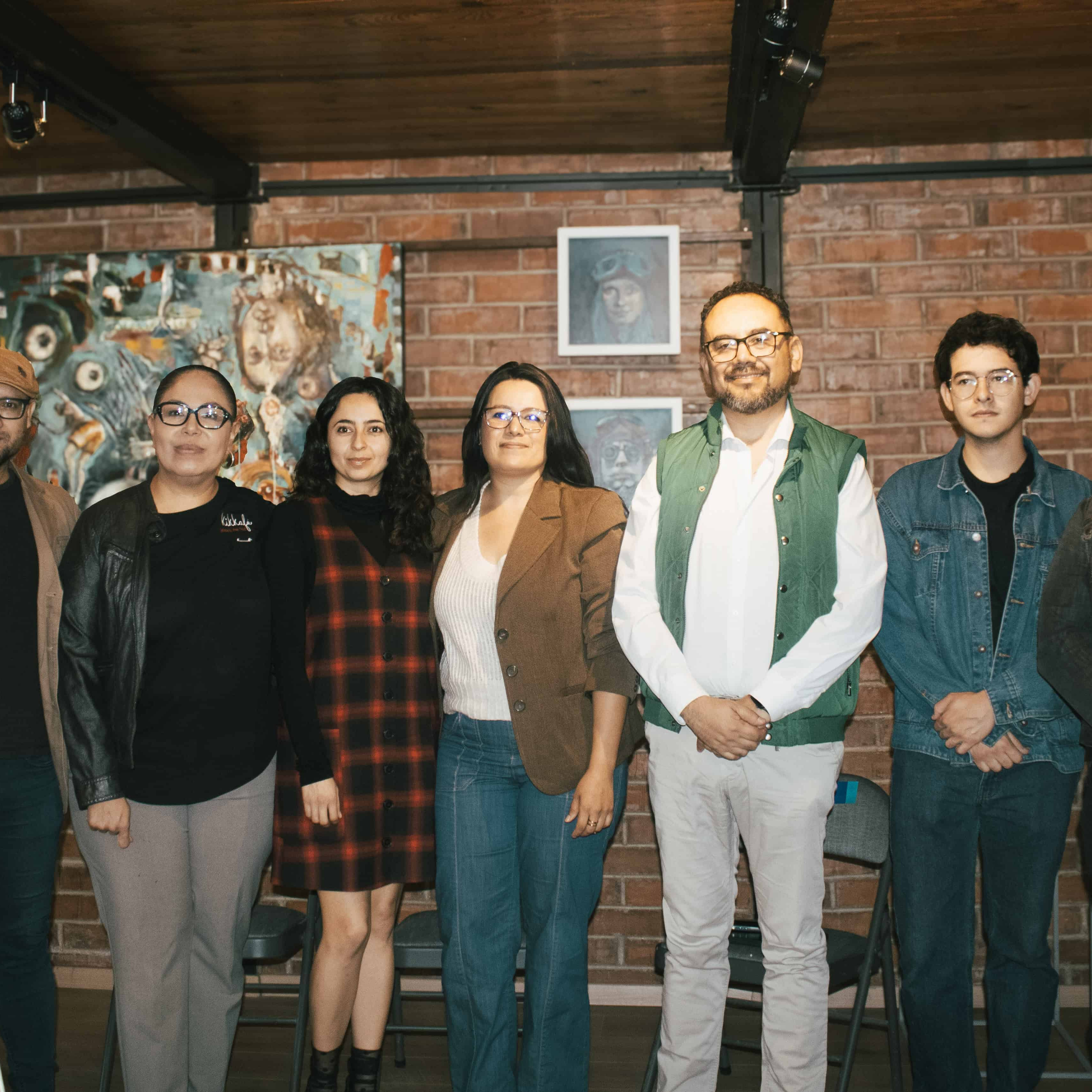 Grupo de personas en una galería de arte en León, México, disfrutando de una exposición cultural.