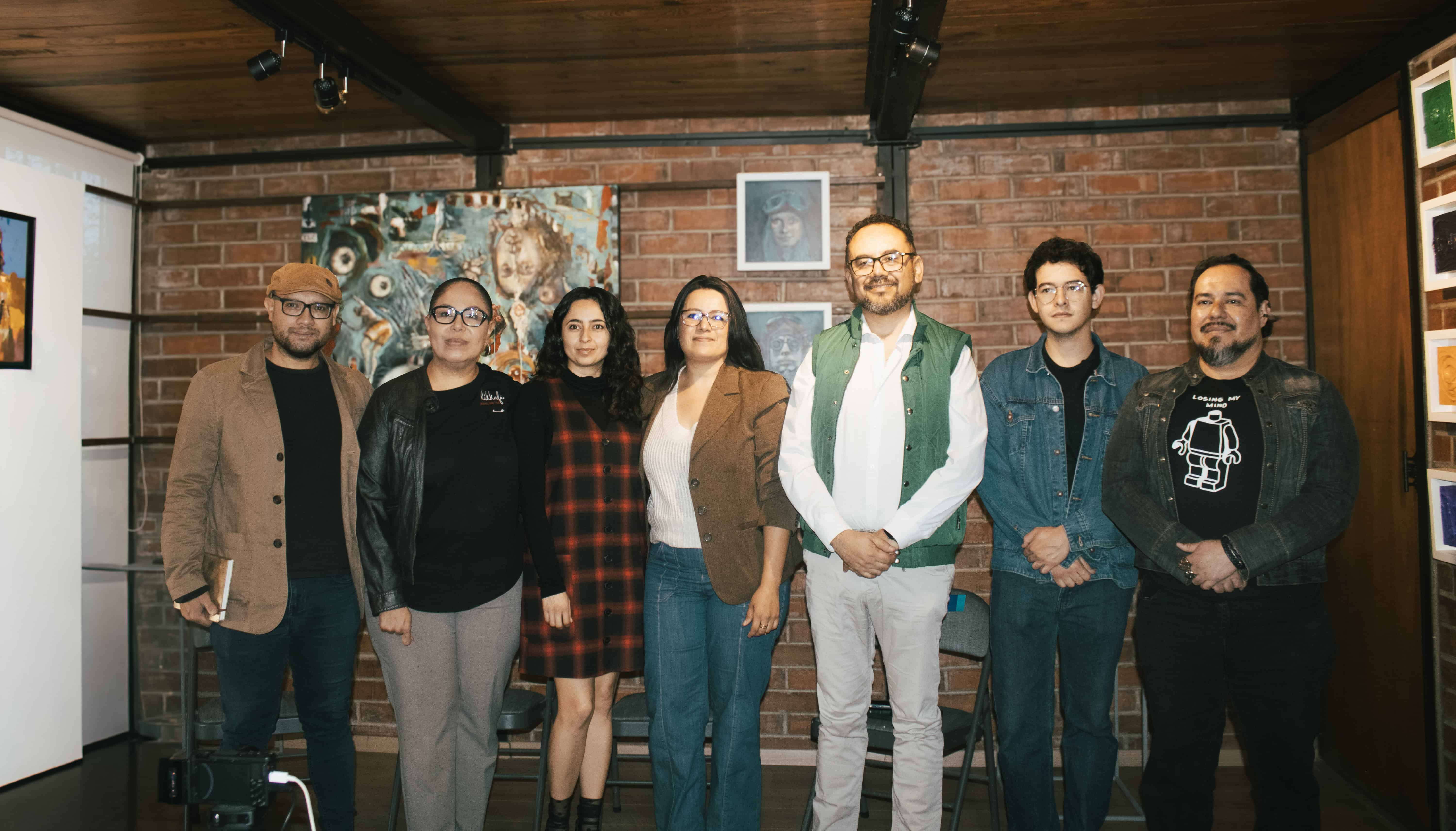 Grupo de personas en una galería de arte en León, México, disfrutando de una exposición cultural.