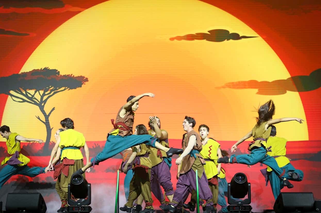 Espectáculo de danza folclórica mexicana con bailarines en vibrantes trajes tradicionales, en un escenario con un hermoso ata.