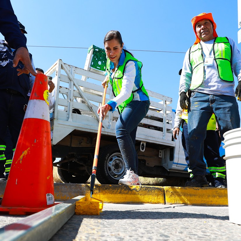 Personal de limpieza trabajando en la calle con equipo de seguridad y herramientas de trabajo.