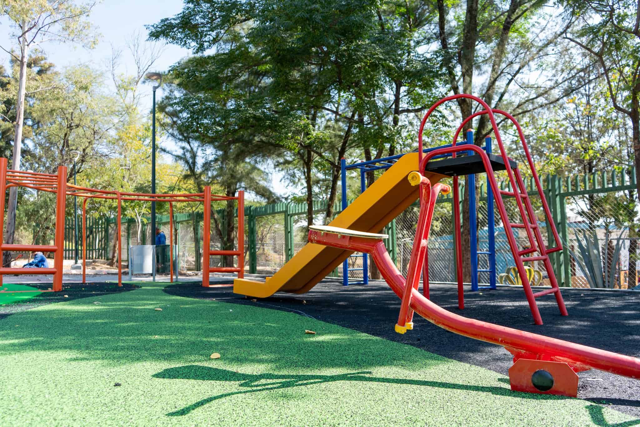 Zona de juegos segura y divertida para ni&ntilde;os en Le&oacute;n, M&eacute;xico, con resbaladilla, columpios y &aacute;reas verdes en un parque familia.