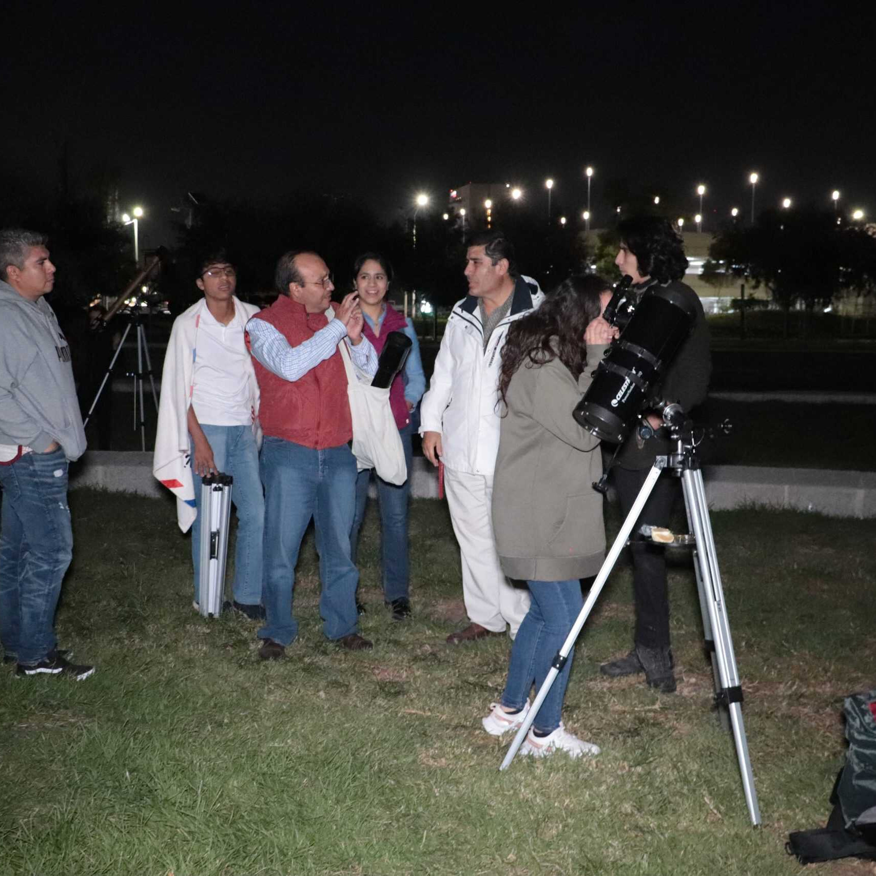 Observatorio nocturno en León, México con telescopios y visitantes disfrutando de la astronomía bajo el cielo estrellado.