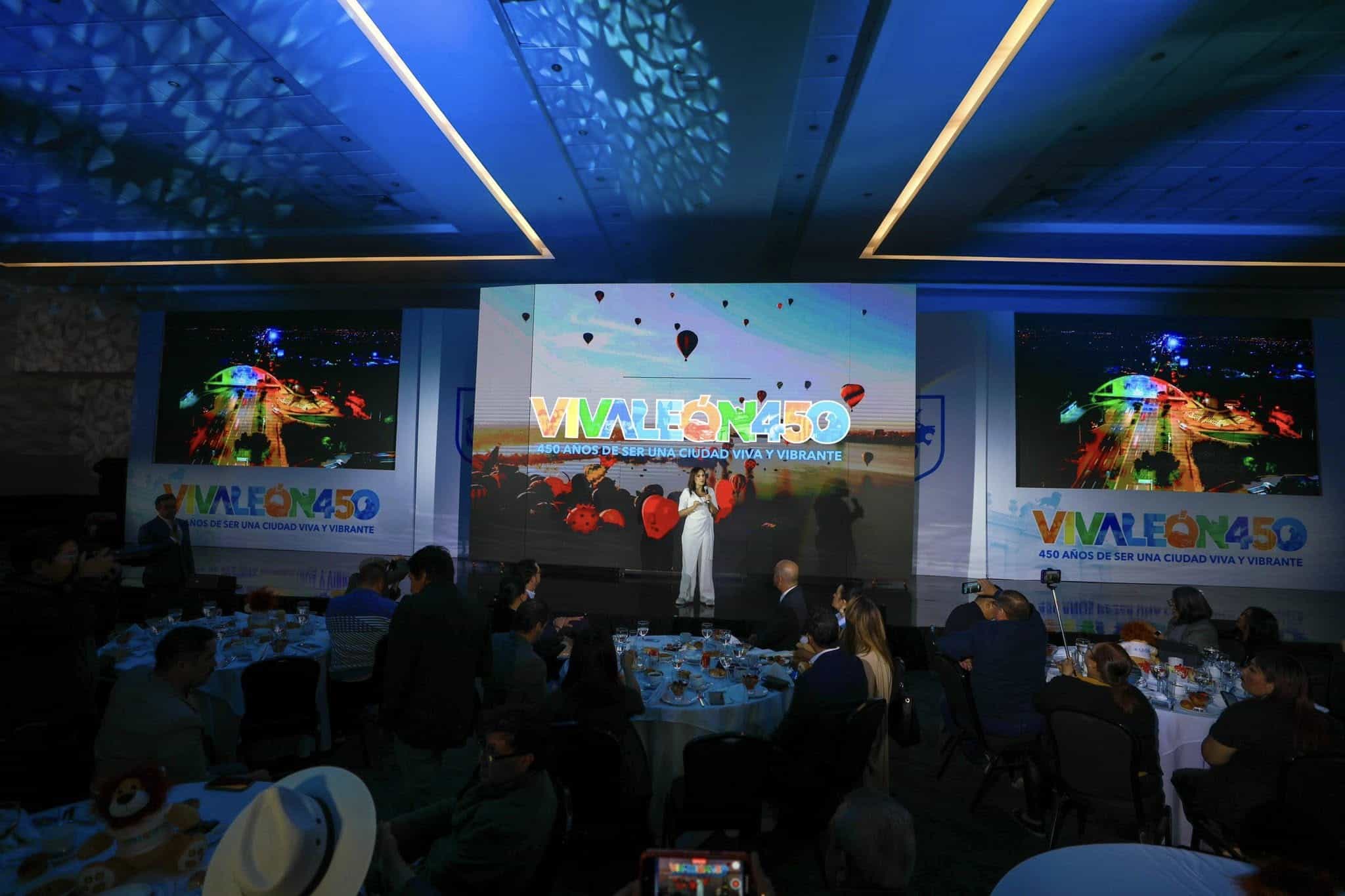 Evento de aniversario con presentaciones y p&uacute;blico disfrutando en un sal&oacute;n elegante.