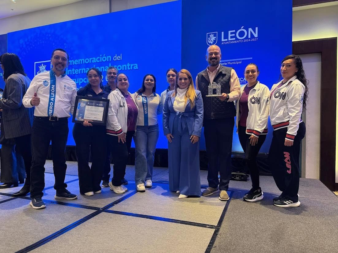Participantes en evento internacional en León, México, con reconocimiento y entrega de premios en un ambiente de colaboración.