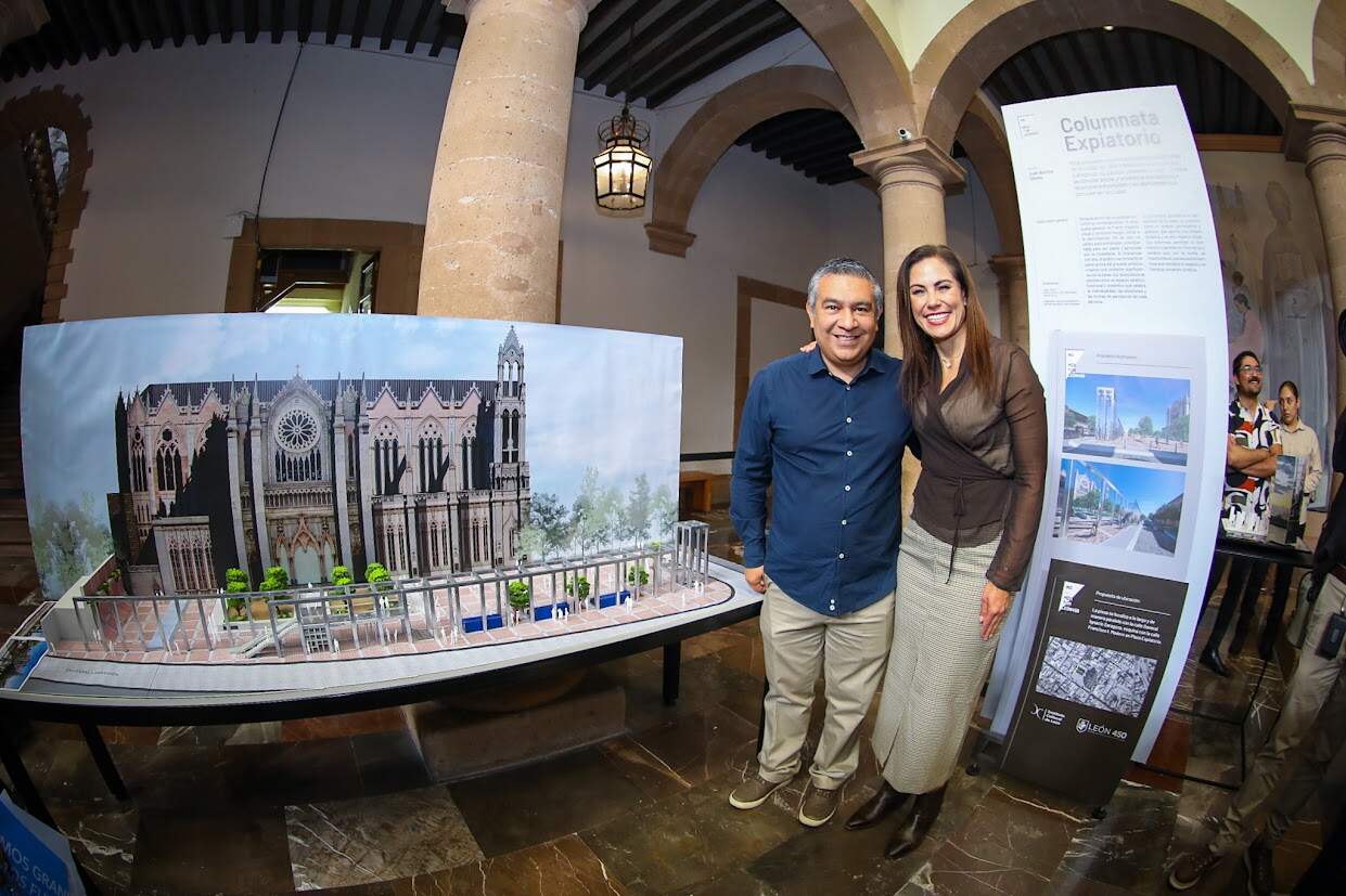 Catedral en exhibición en evento cultural en León, Guanajuato, con visitantes admirando la maqueta y la historia del monument.
