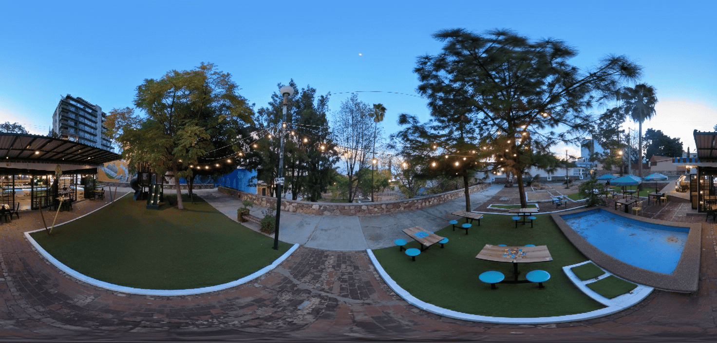 Piscina al aire libre en León, con áreas de descanso, árboles y ambiente relajante, ideal para disfrutar del clima y la natur.