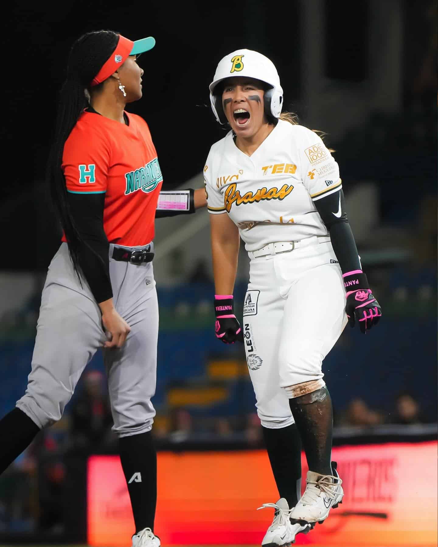 Jugadora de b&eacute;isbol femenina celebrando en el campo con entusiasmo y alegr&iacute;a.