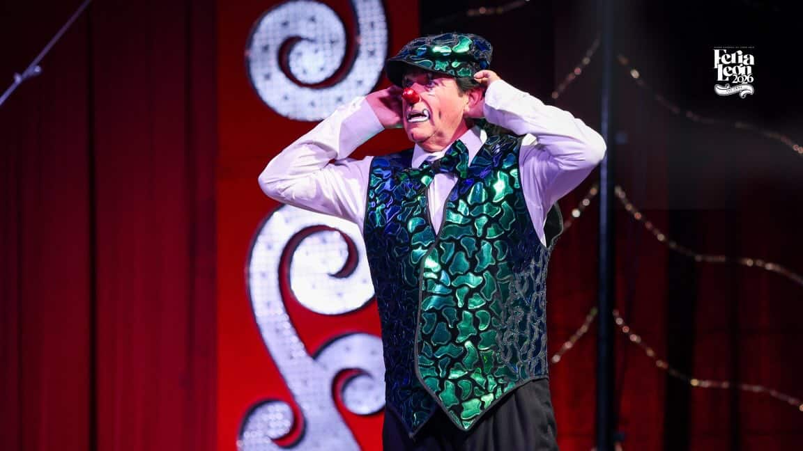 Actor en vestuario colorido durante presentaci&oacute;n teatral en Le&oacute;n, M&eacute;xico, en un escenario con fondo rojo y decoraciones lumin.