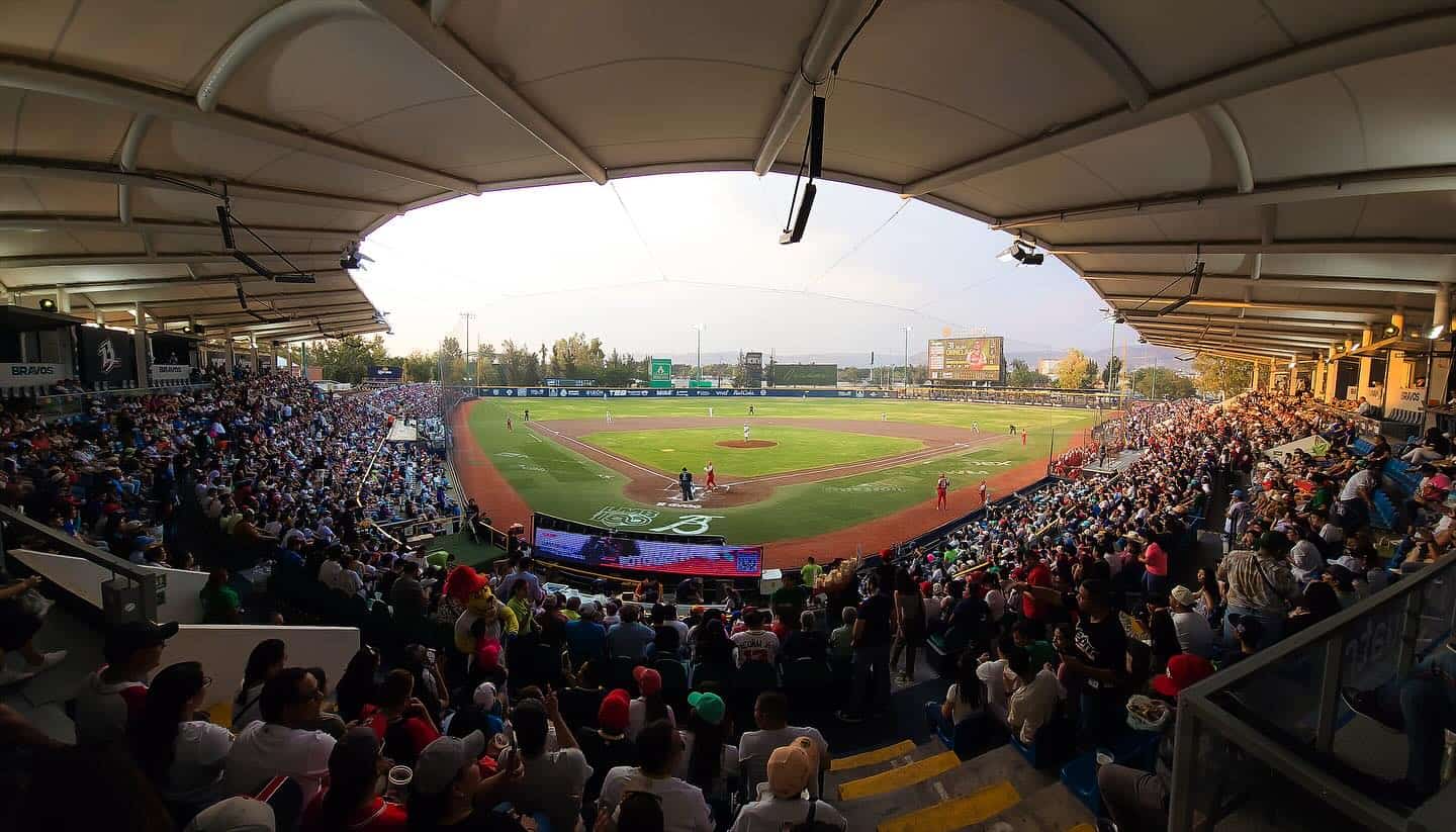 Estadio de béisbol lleno de espectadores en un juego en León, México, con ambiente vibrante y emocionante.