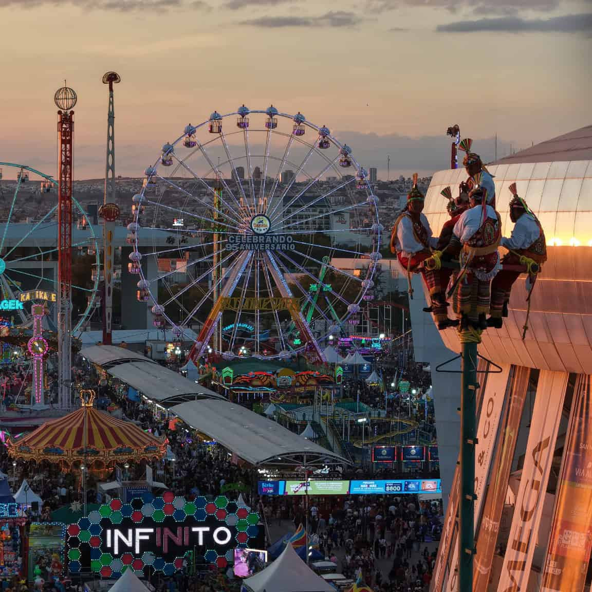 Vista panorámica de la feria con noria gigante y juegos mecánicos en León, México, ideal para turistas y familias que buscan.