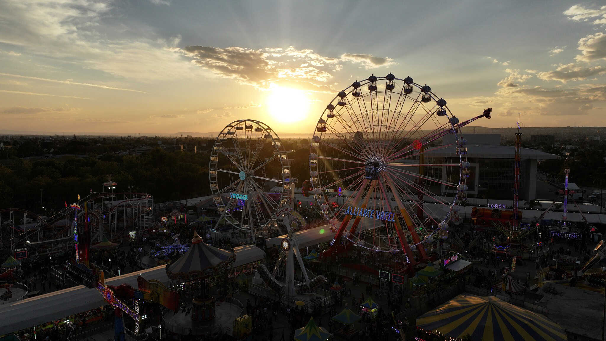 Ruedas de la feria en Le&oacute;n, Guanajuato con vista al atardecer, atracci&oacute;n principal y diversi&oacute;n para toda la familia en la ciu.