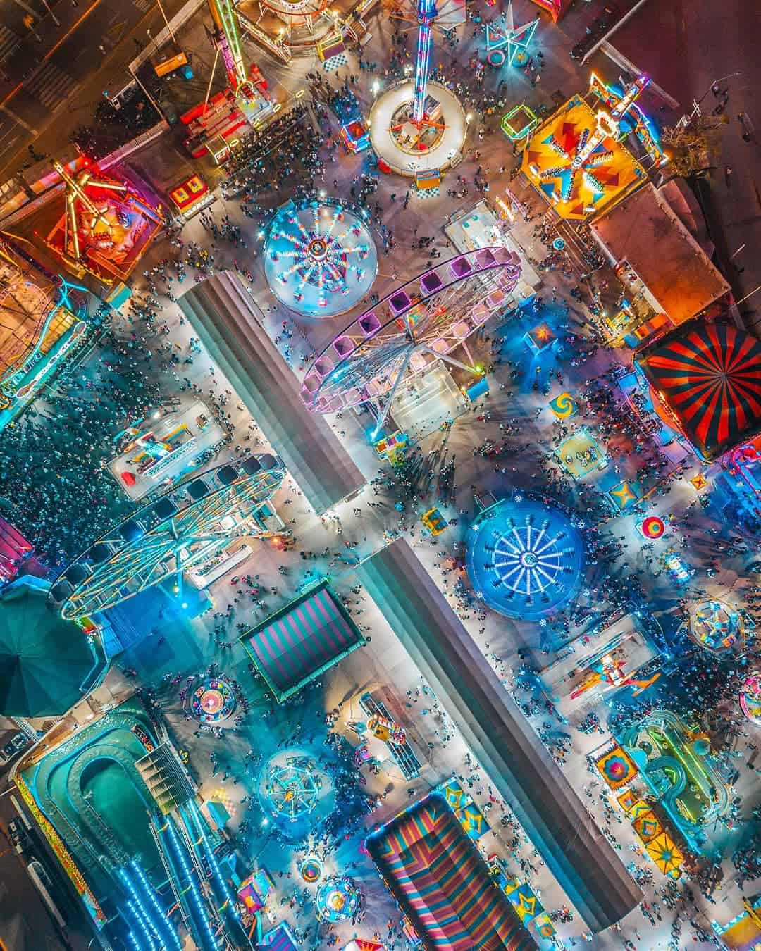 Feria de Le&oacute;n con atracciones, juegos y luces vibrantes en un parque de diversiones nocturno.