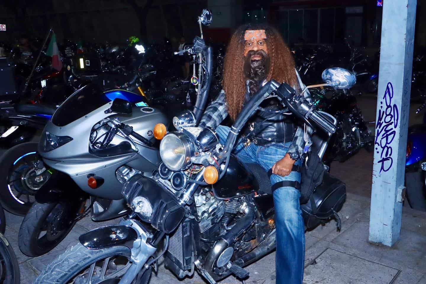 Motociclista con barba y cabello rizado en motocicleta en la calle de Le&oacute;n, M&eacute;xico, mostrando un estilo urbano y aventurero.