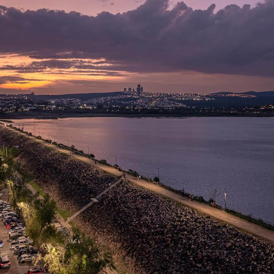 Paisaje nocturno del lago de León con vista urbana al fondo, resaltando la belleza natural y la tranquilidad del destino turí.