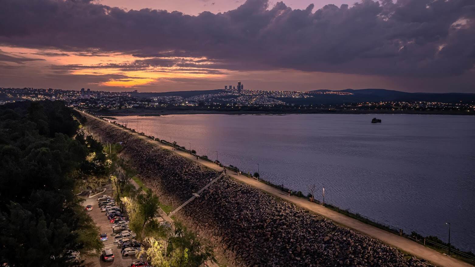 Paisaje nocturno del lago de Le&oacute;n con vista urbana al fondo, resaltando la belleza natural y la tranquilidad del destino tur&iacute;.