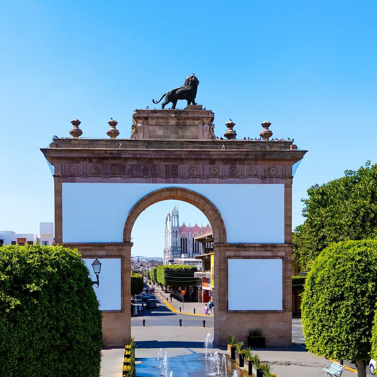 Puerta de León, entrada emblemática en la ciudad de León, con arquitectura colonial y un monumento de un toro en la cima.