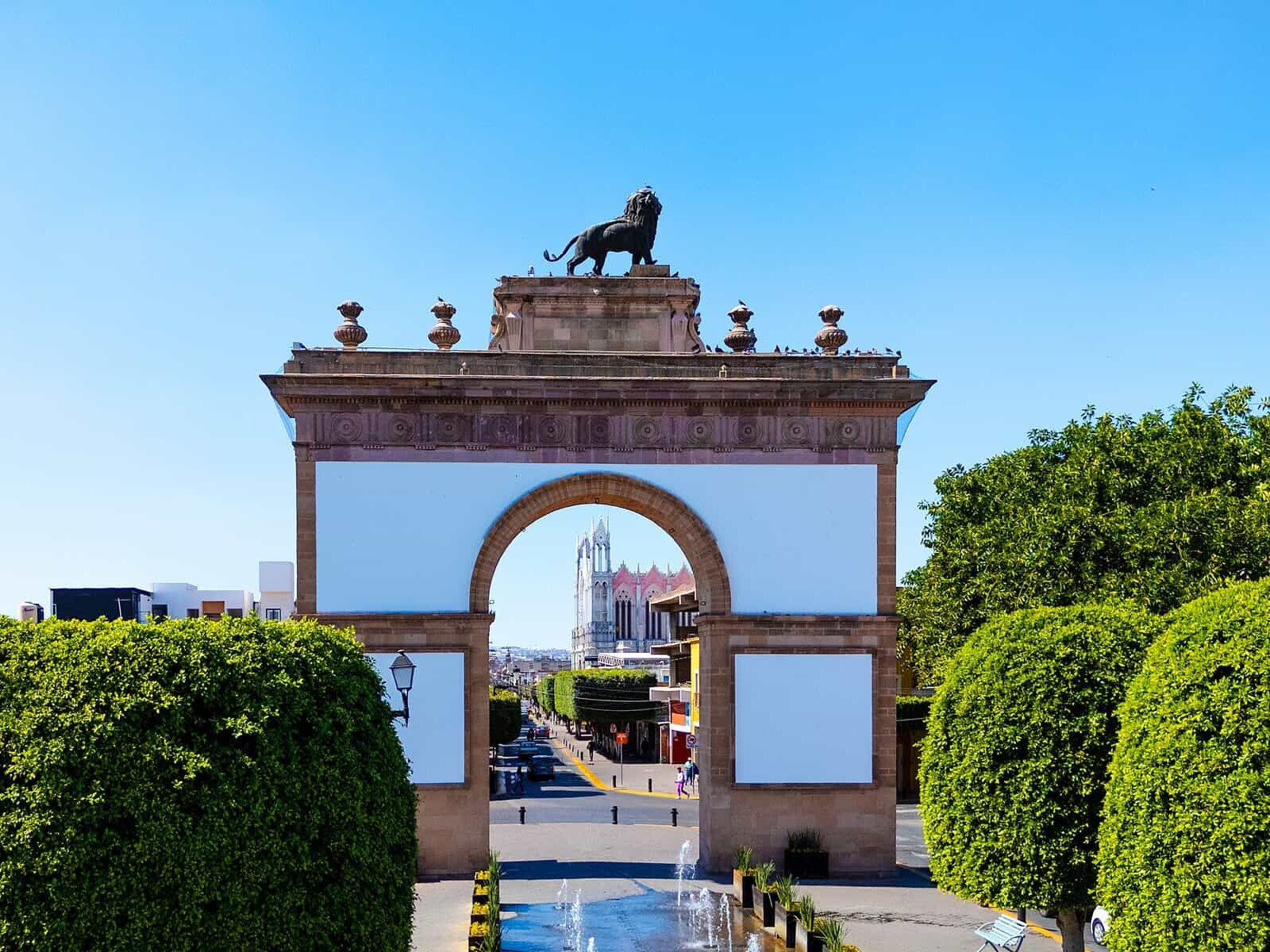 Puerta de León, entrada emblemática en la ciudad de León, con arquitectura colonial y un monumento de un toro en la cima.