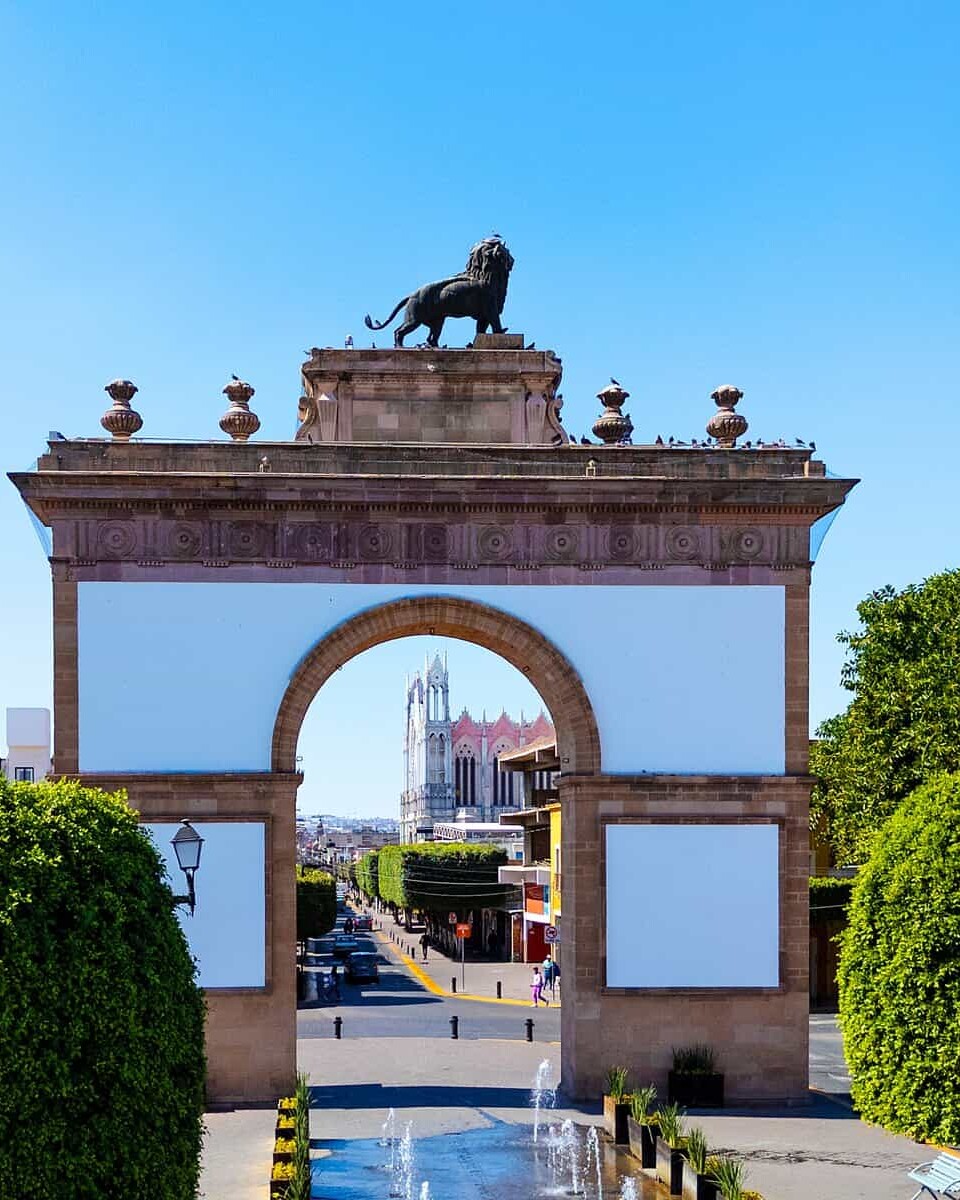Puerta de León, entrada emblemática en la ciudad de León, con arquitectura colonial y un monumento de un toro en la cima.