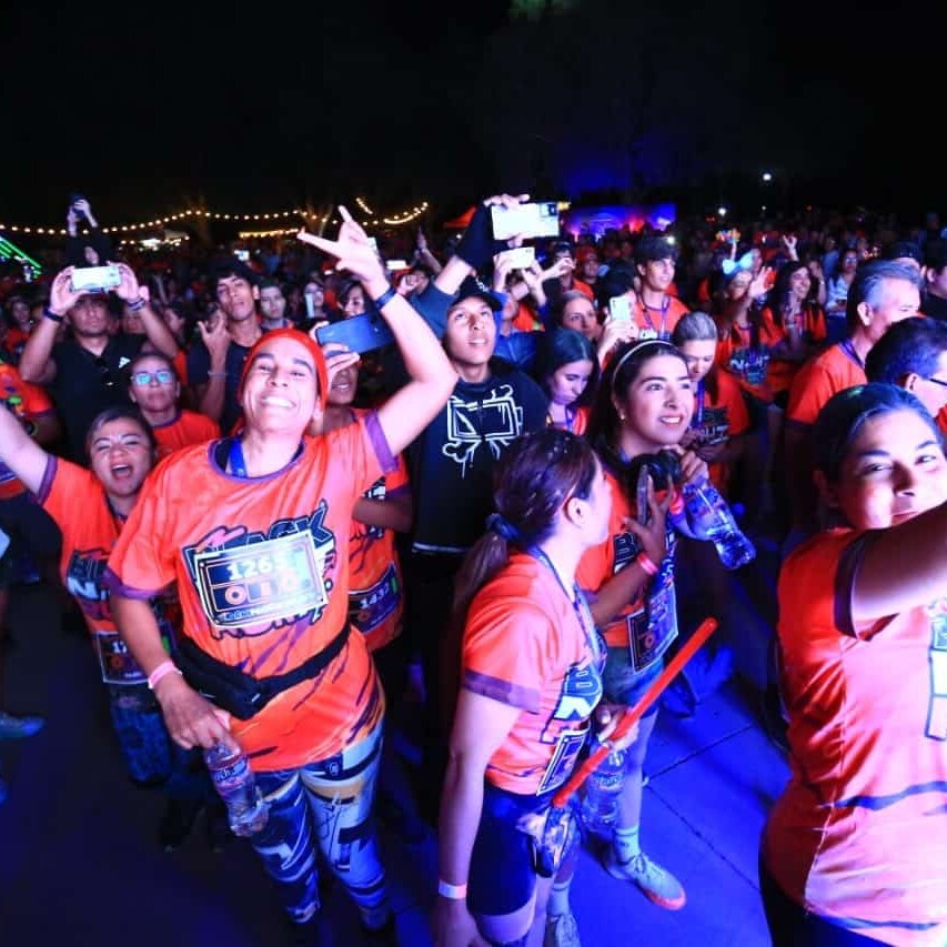 Personas disfrutando la noche en la Black Night Run 2026, con luces, música y energía en un evento inolvidable en León, Méxic.
