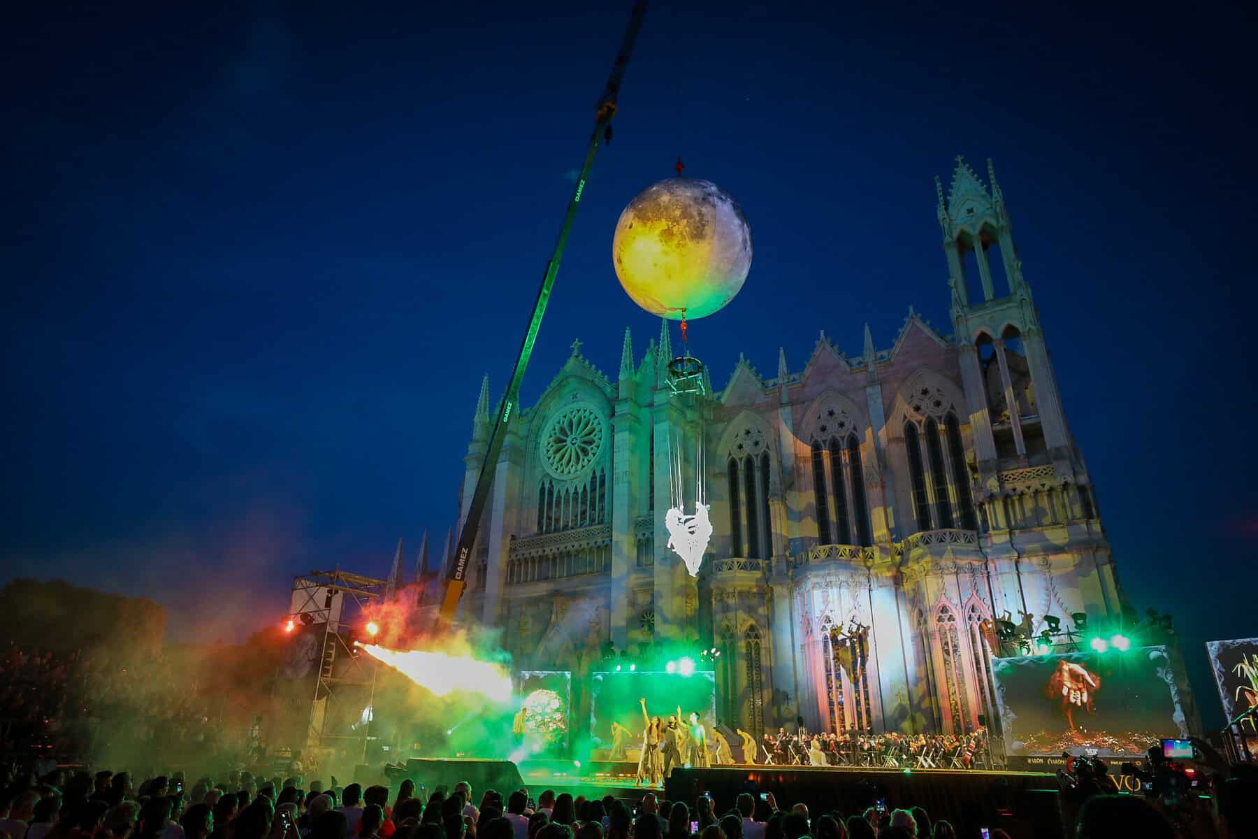 Espect&aacute;culo nocturno en la Catedral de Le&oacute;n con luces, m&uacute;sica y un globo gigante en el cielo, creando un ambiente m&aacute;gico y fe.