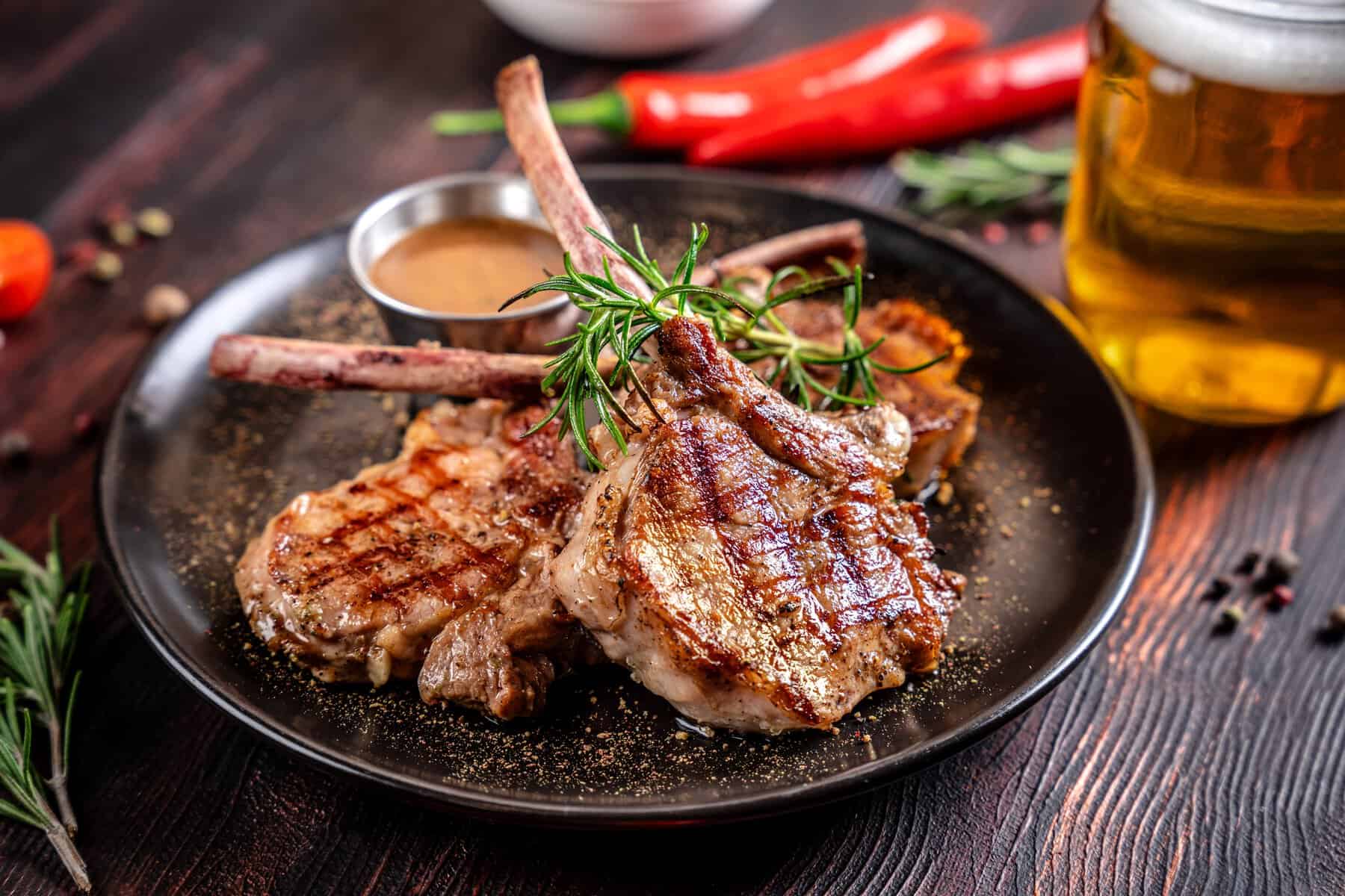 Deliciosos costillares de carne asada acompa&ntilde;ados de hierbas frescas y una cerveza fr&iacute;a, perfectos para disfrutar en Le&oacute;n, M&eacute;.