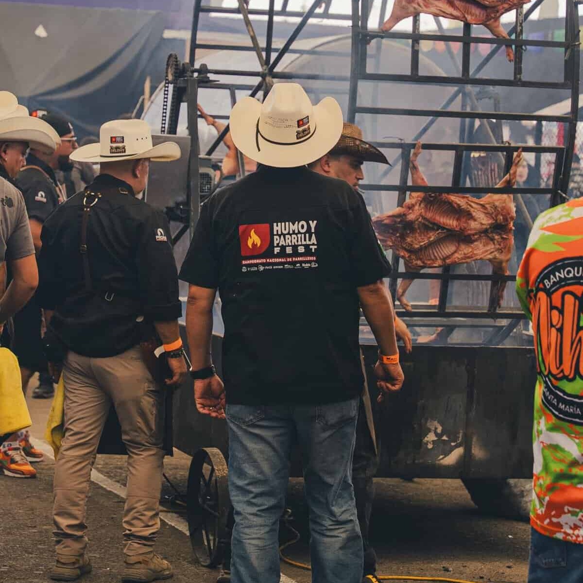 Asador de carne con parrilla gigante y carne asada en festival cultural en León, México.