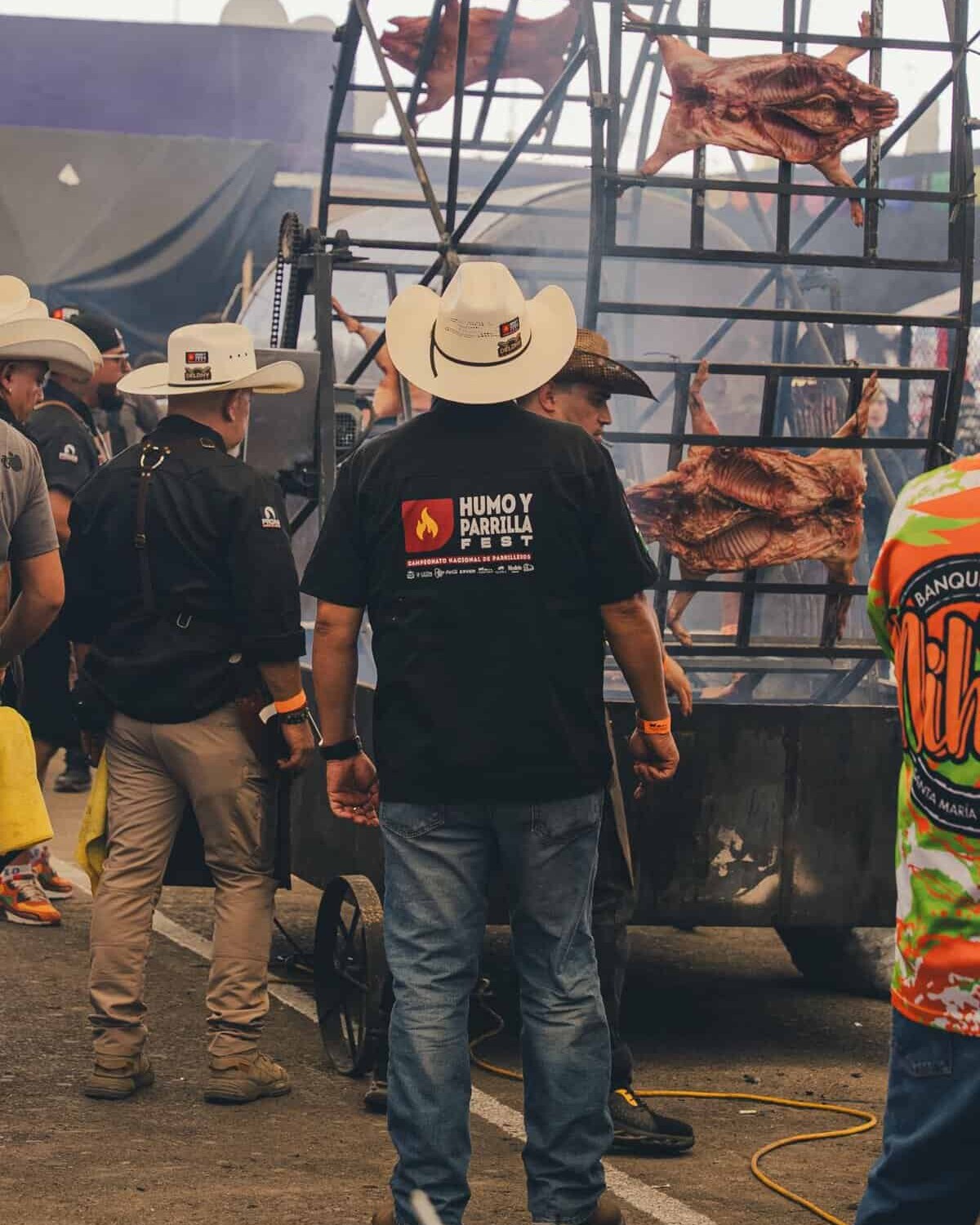 Asador de carne con parrilla gigante y carne asada en festival cultural en León, México.