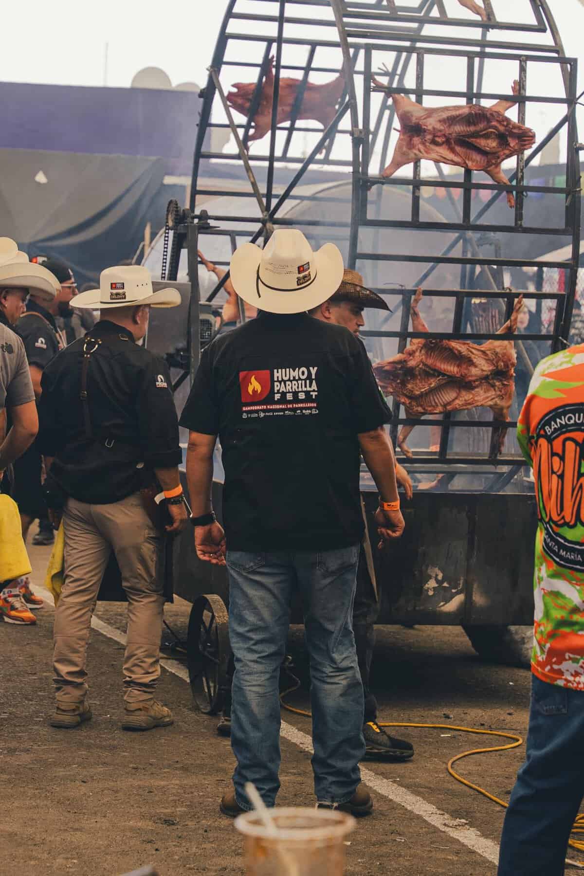 Asador de carne con parrilla gigante y carne asada en festival cultural en Le&oacute;n, M&eacute;xico.