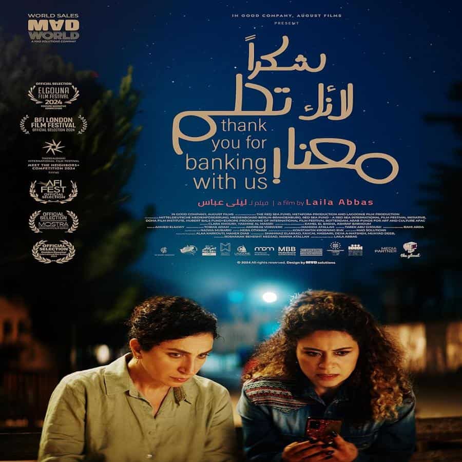Cartel de la película en la calle con dos mujeres mirando sus teléfonos en la noche.