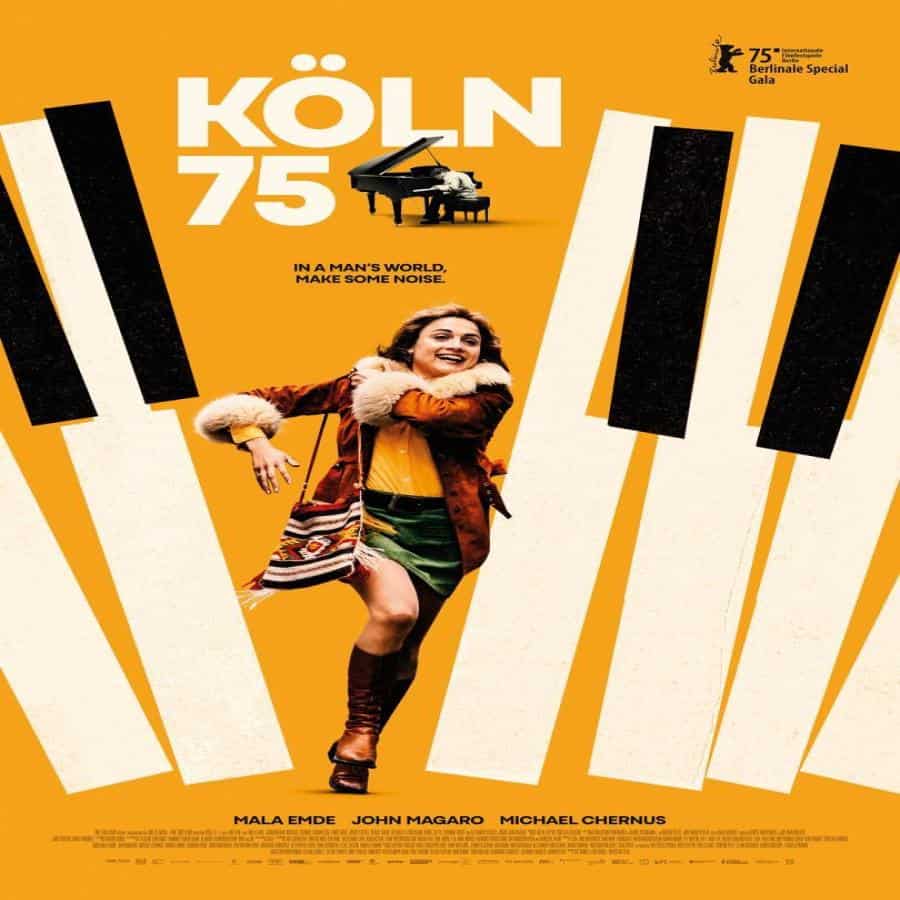 Cartel promocional del concierto de KÖLN 75, destacando un piano y una mujer feliz en un fondo color naranja.