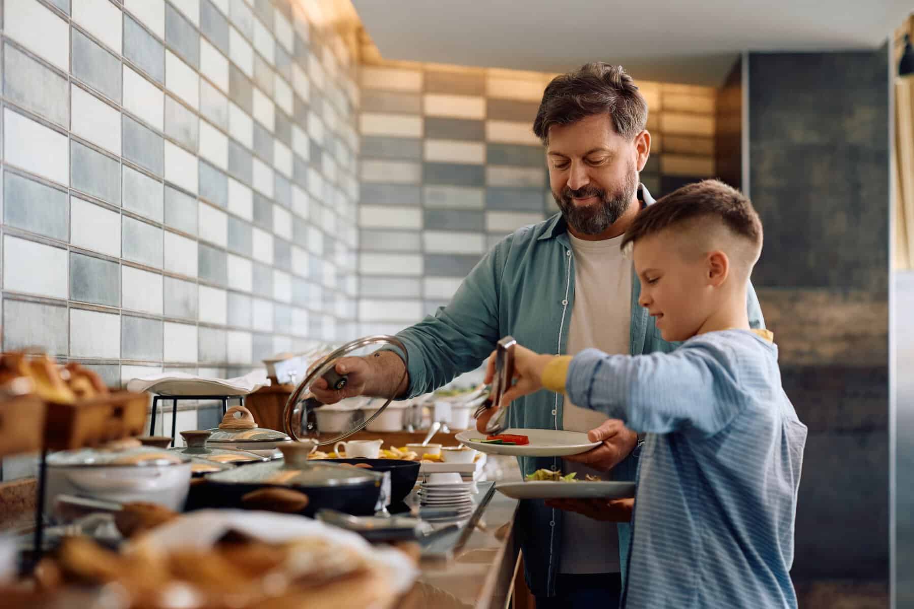 Padre e hijo sirvi&eacute;ndose comida en un restaurante con ambiente moderno y acogedor en Le&oacute;n, M&eacute;xico.