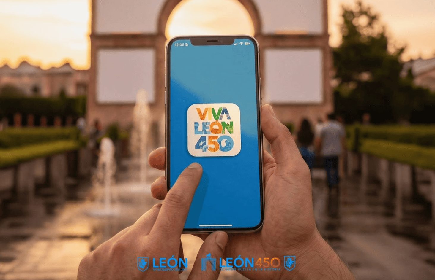 Persona sosteniendo un teléfono con el logo de Viva León 450 en un fondo de monumento y fuentes al atardecer.