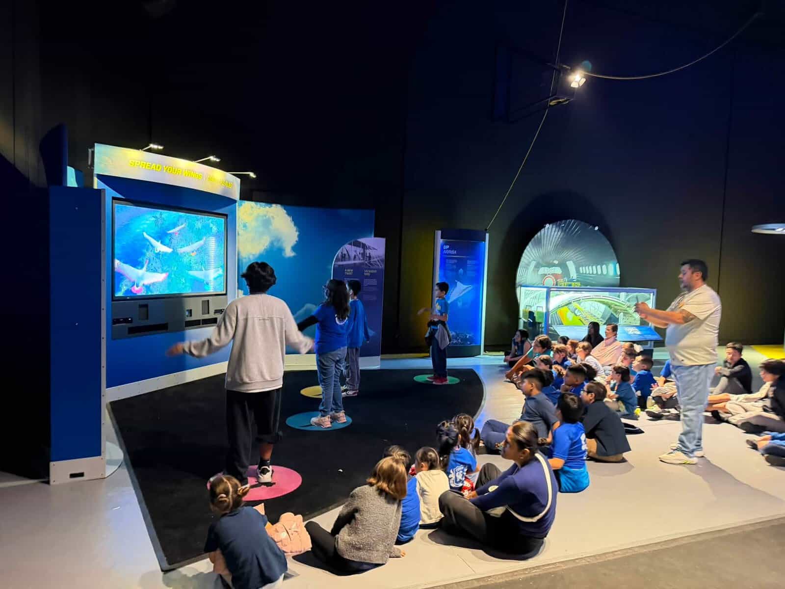 Niños y adultos disfrutando de una experiencia espacial en un centro de ciencia en León, Guanajuato, México.