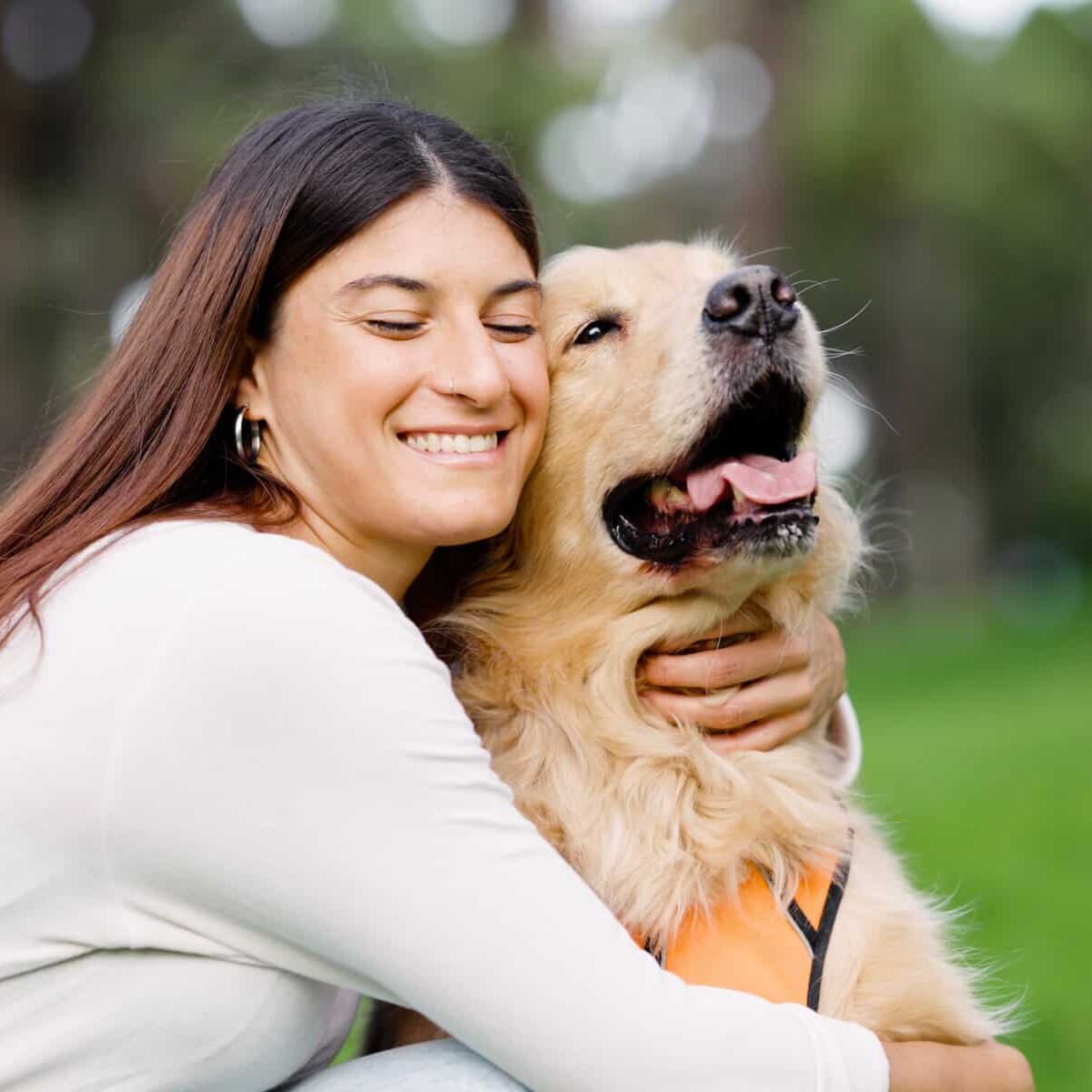 Mujer feliz abrazando a su perro en parque de León, Guanajuato, México, disfrutando del Día Mundial del Perro.
