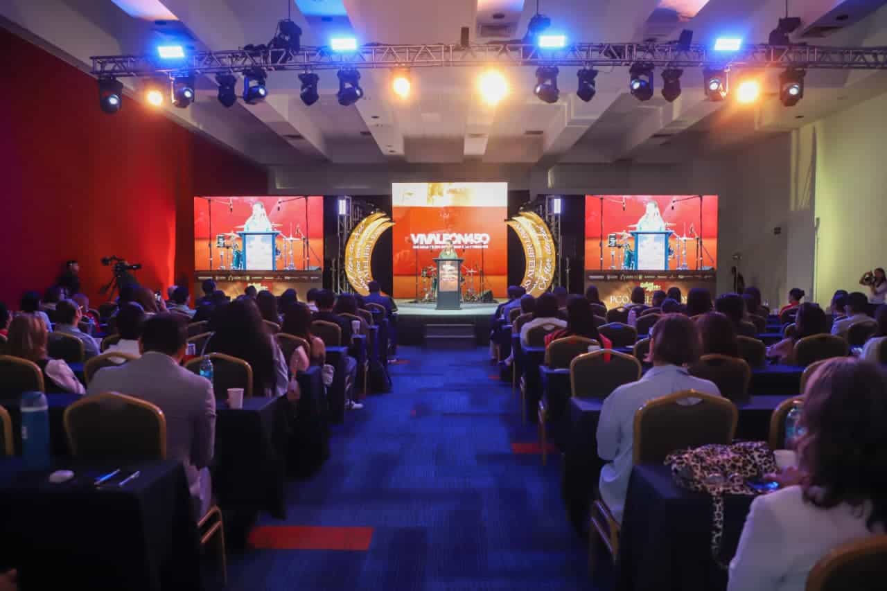 Conferencia en León, evento de reuniones y negocios, con audiencia y escenario iluminado para la industria de reuniones en M.