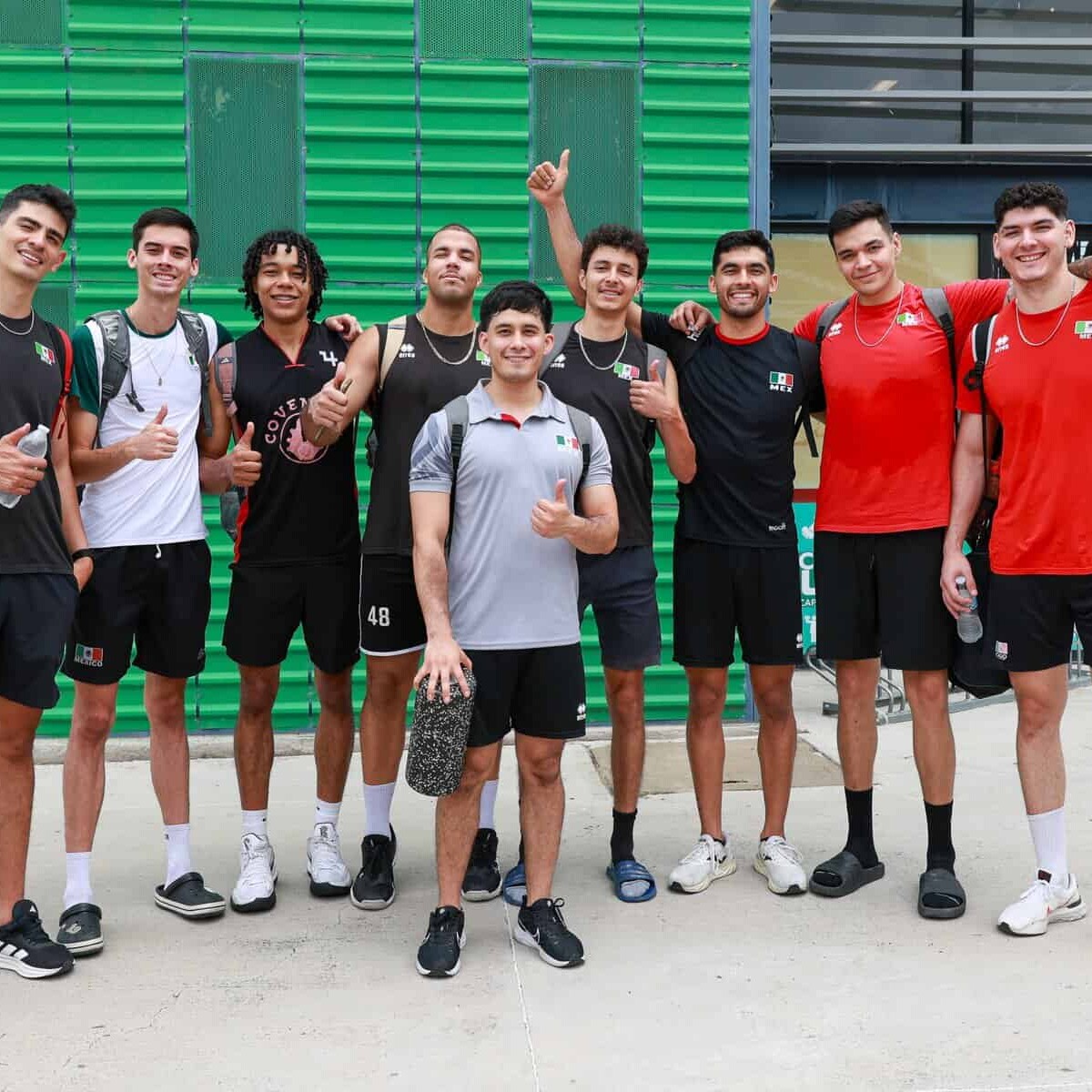 Jugadores de baloncesto en entrenamiento en León, México, posando juntos con entusiasmo y mostrando su espíritu deportivo.