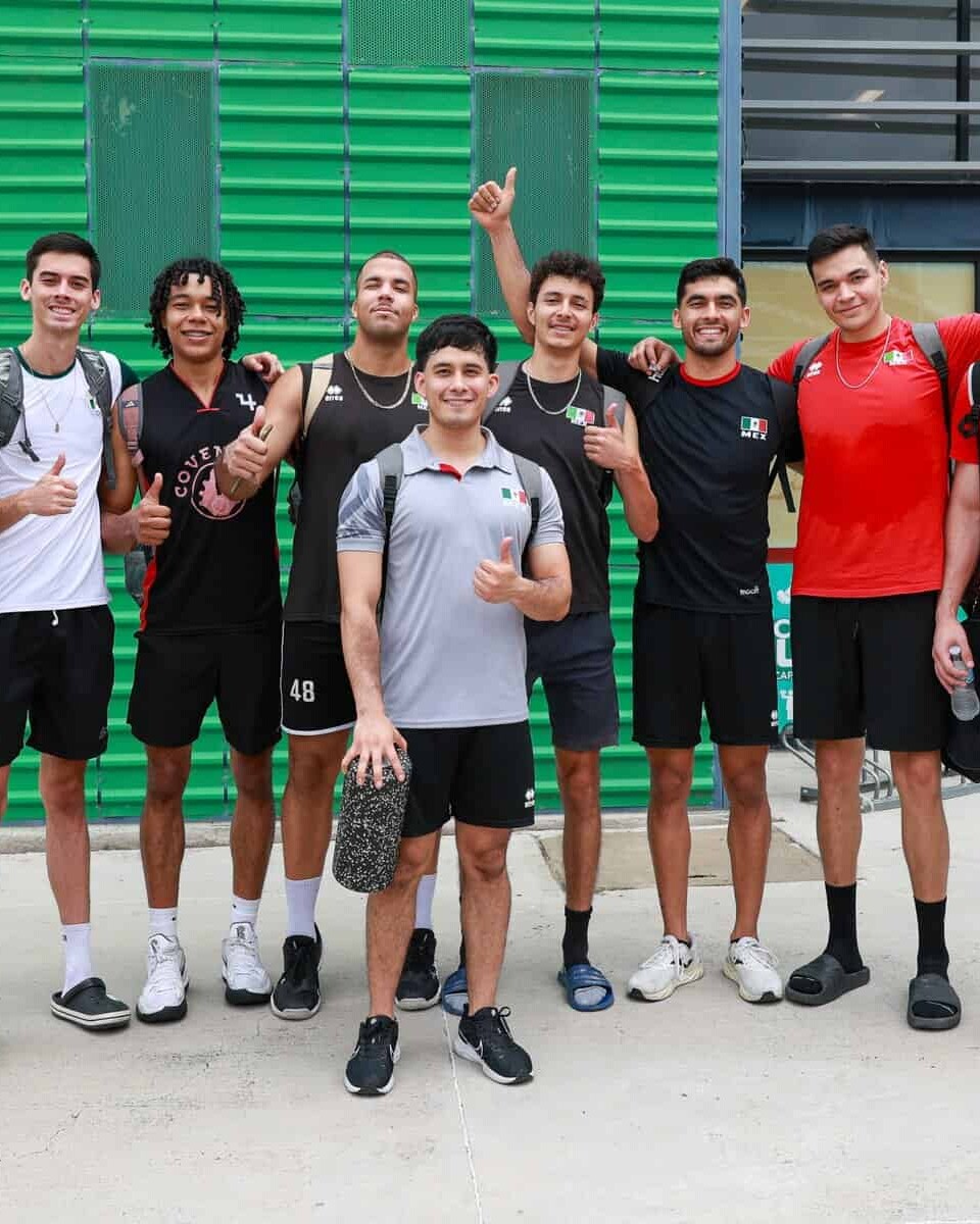 Jugadores de baloncesto en entrenamiento en León, México, posando juntos con entusiasmo y mostrando su espíritu deportivo.