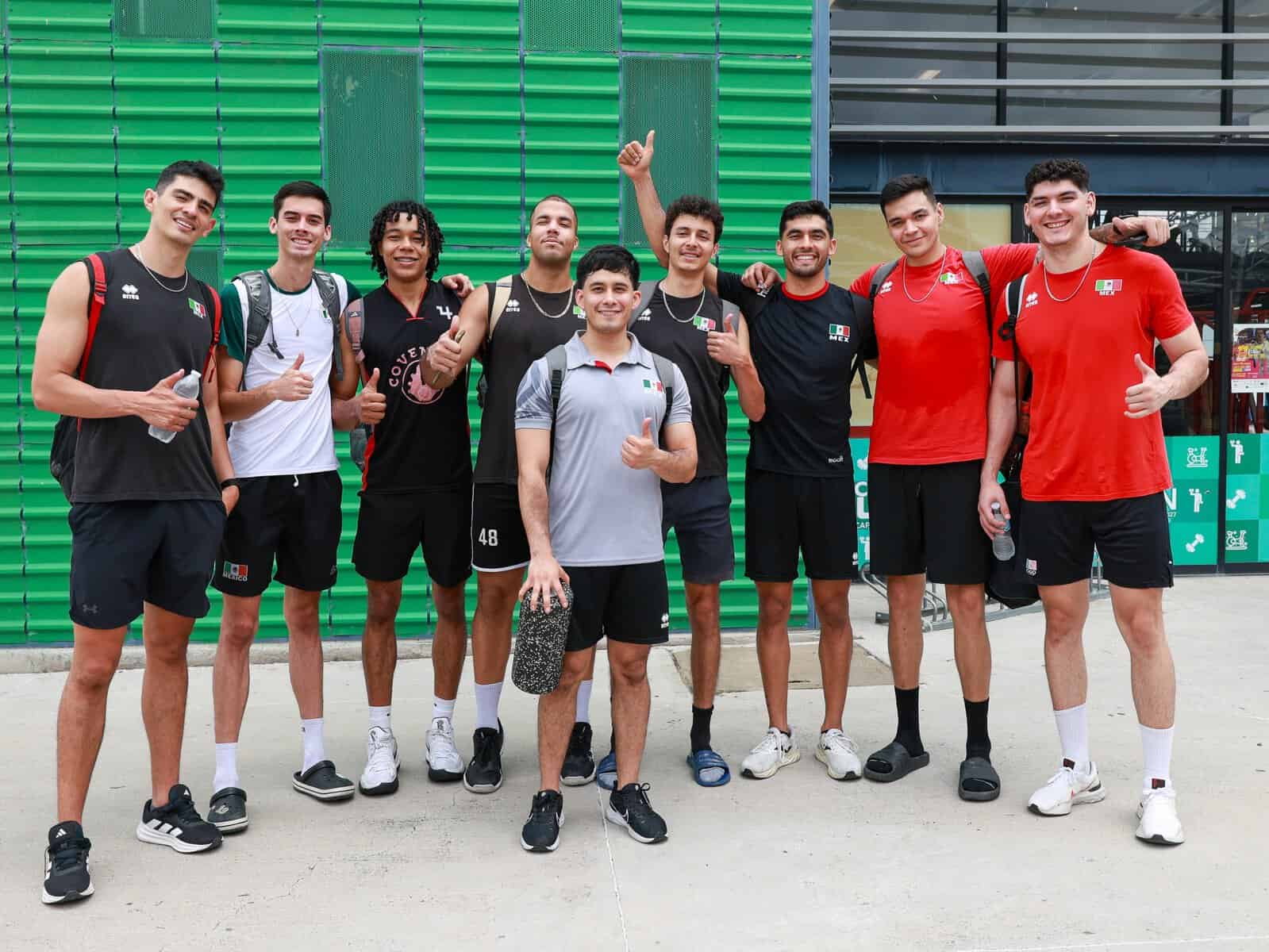 Jugadores de baloncesto en entrenamiento en León, México, posando juntos con entusiasmo y mostrando su espíritu deportivo.