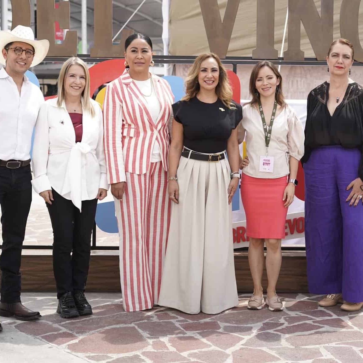 Grupo de mujeres y un hombre en evento de vino en León, Guanajuato, México, con ambiente festivo y elegante.