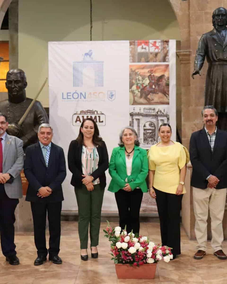 Grupo de personas en evento cultural en León, Guanajuato, con estatuas y exhibiciones históricas.